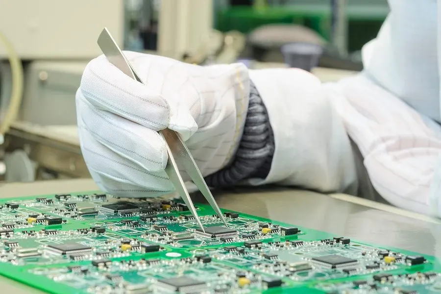 A technician working on SMT assembly at a workstation.