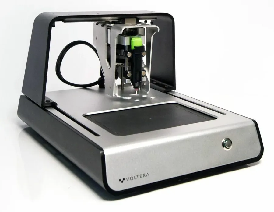 A desktop PCB printer on a workbench.