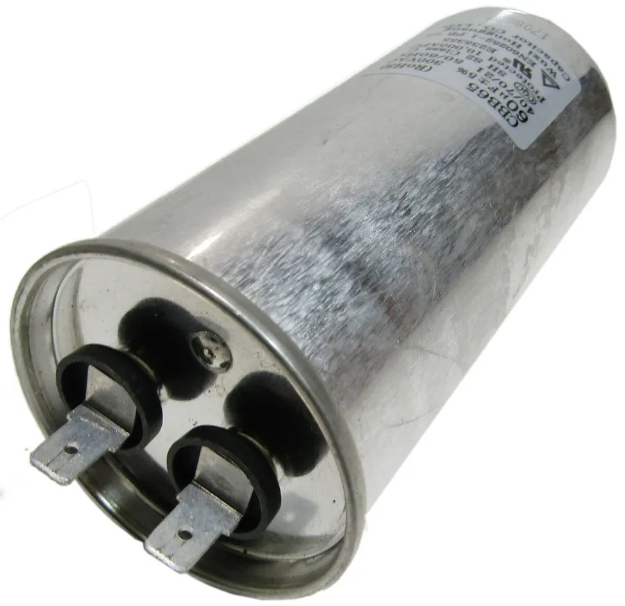 Hands replacing a CBB65 capacitor in an appliance.