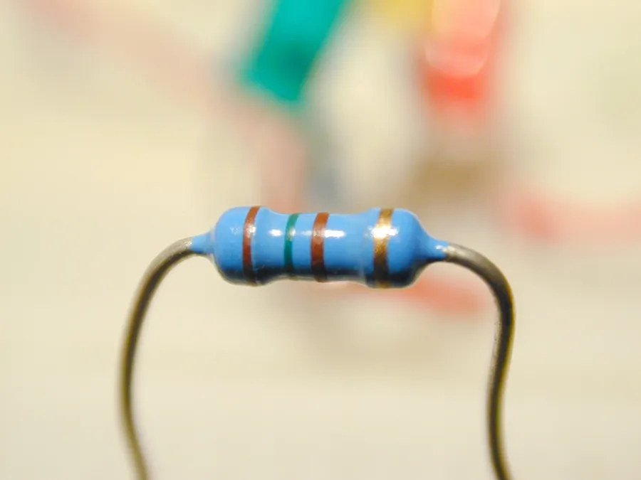 A close up view of a single resistor with its color bands visible.