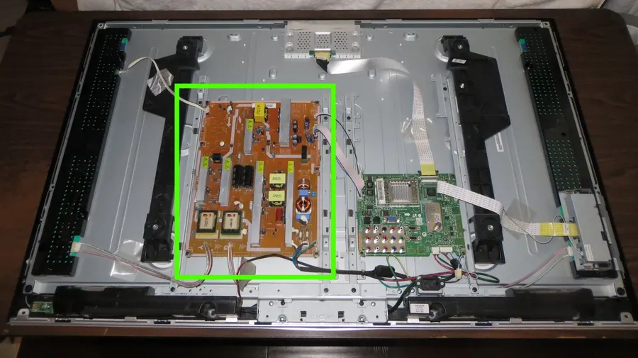 A close-up of a damaged TV circuit board with signs of burnt components.