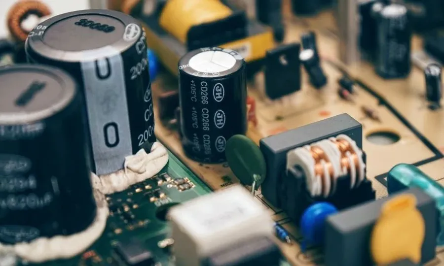 A circuit board with various capacitors soldered onto it.