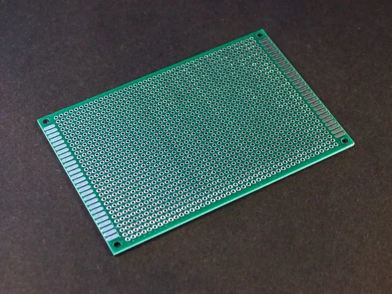 A hand holding a newly manufactured PCB prototype board