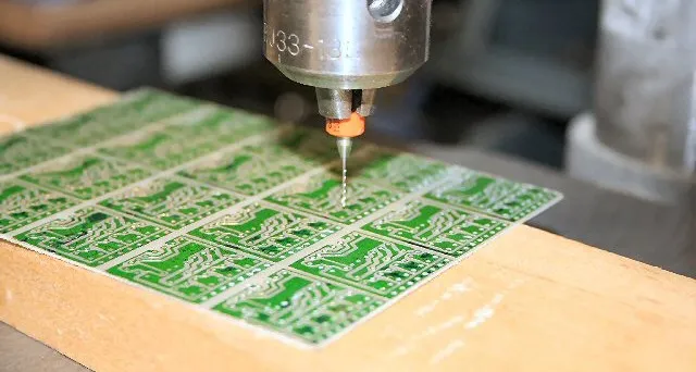 A PCB drilling machine in operation, creating holes and vias on a PCB.