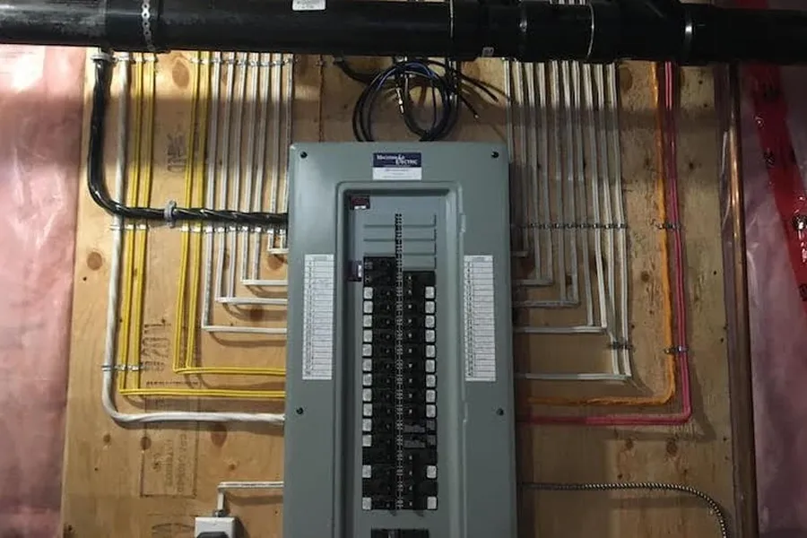 An electrician installing an electrical panel in a home.