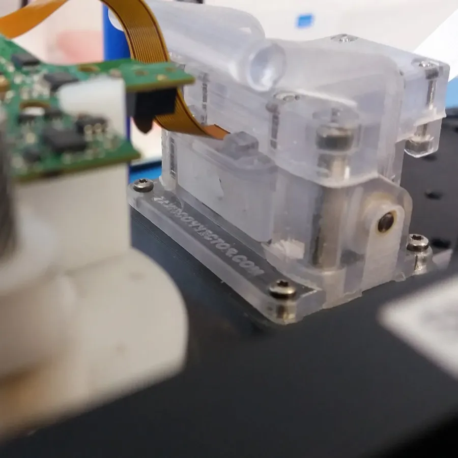 A technician inspecting a flexible circuit board with testing equipment.