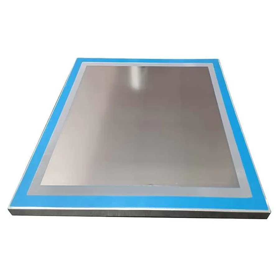 A stainless steel SMT stencil on a workbench.