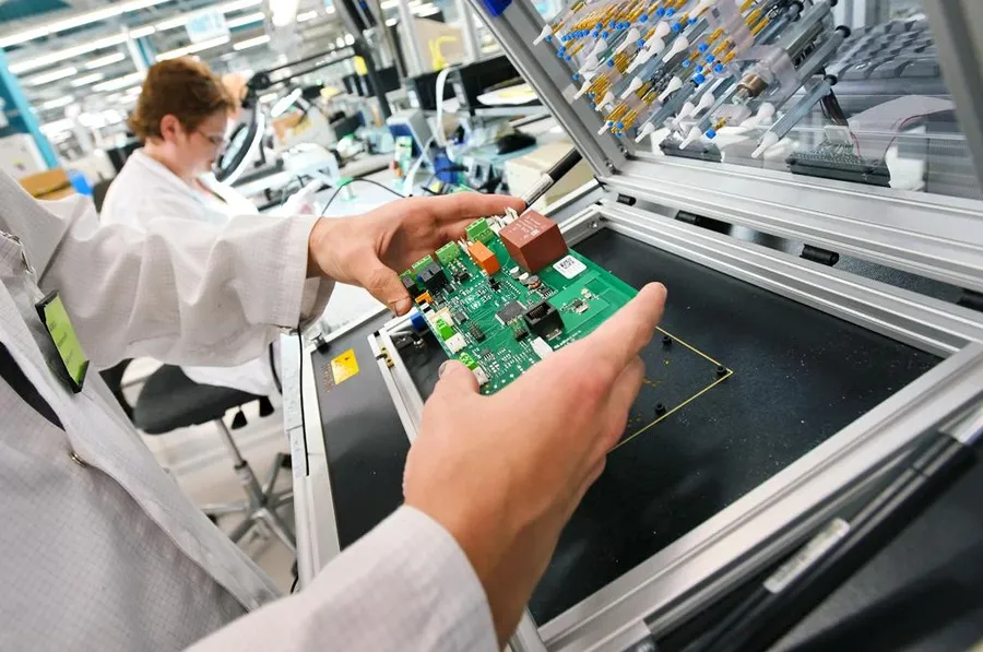 A technician using equipment to perform functional testing on a PCB.