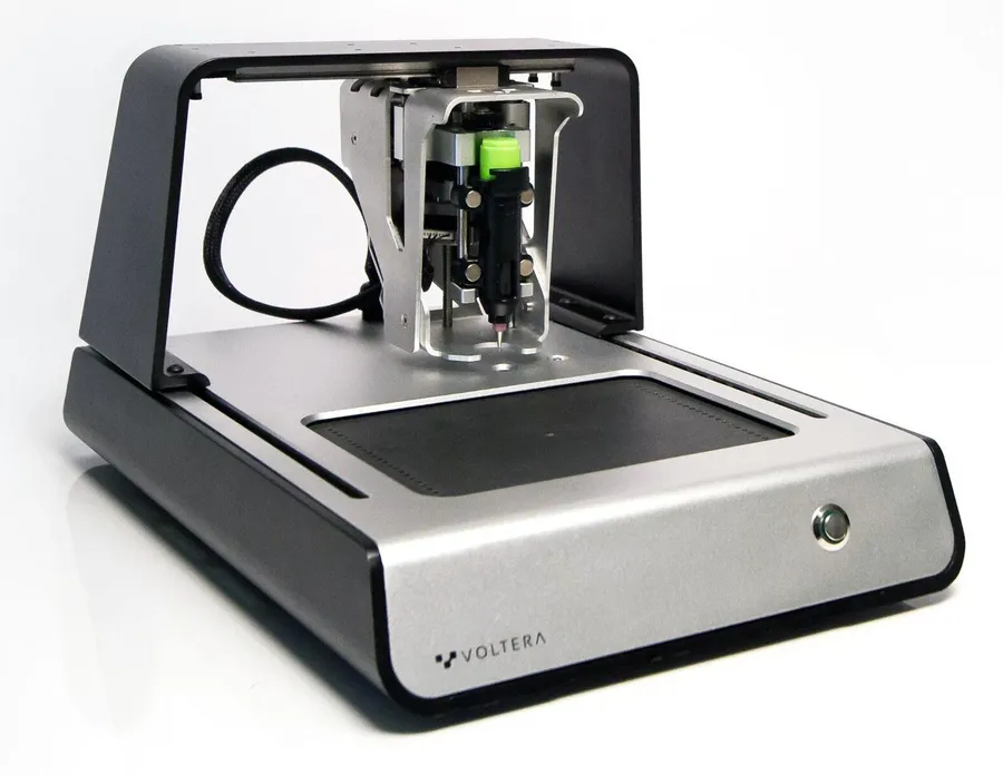 An electronics engineer working with the Voltera V-One on a workbench.