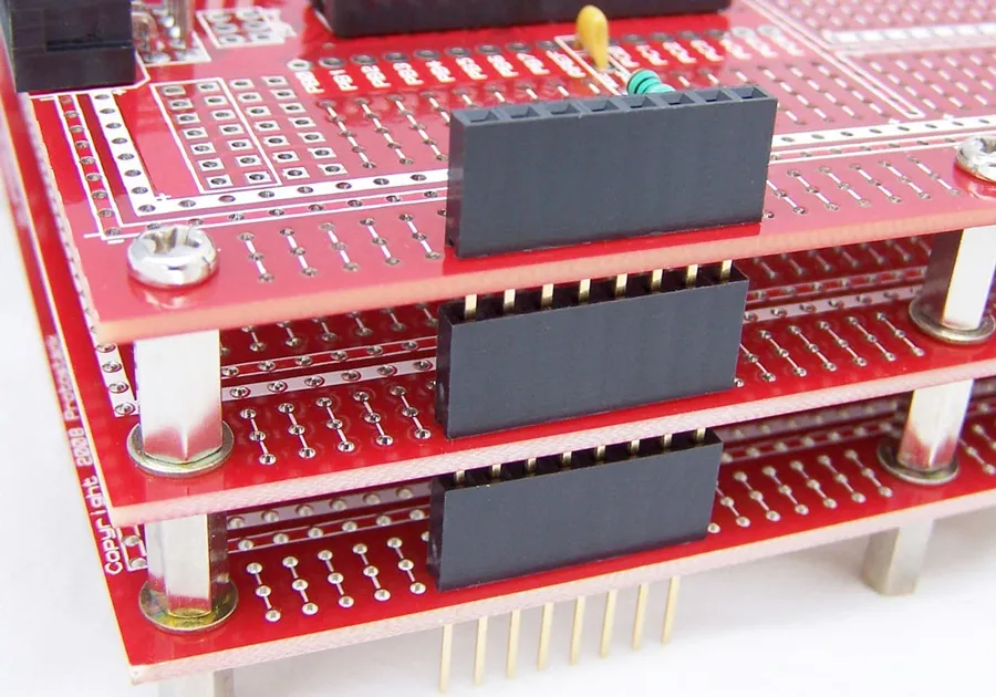 A stack of printed circuit boards, indicating a large production volume.