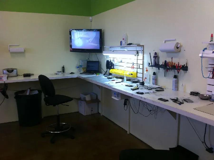 A repair shop setting with various tools and a mobile PCB stand.