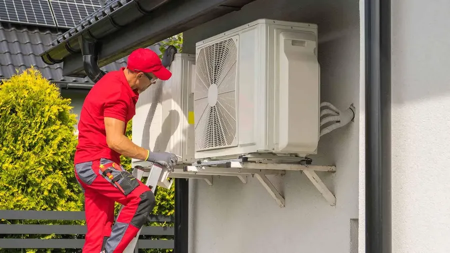 A technician replacing a capacitor in an air conditioning unit.