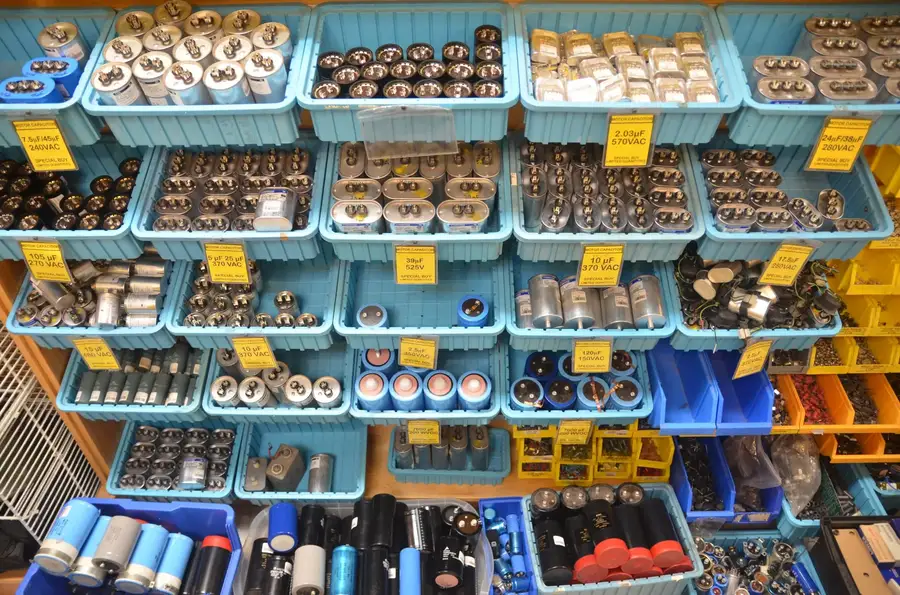 A shelf filled with various electronic components including capacitors in a store.