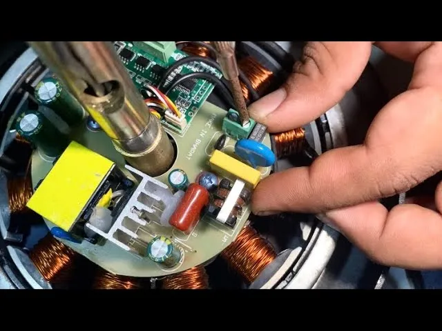 A person replacing a circuit board in a BLDC fan.