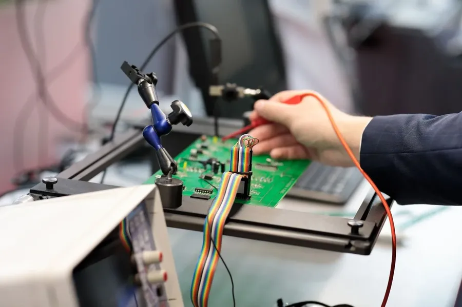A microwave PCB prototype undergoing testing with various instruments.