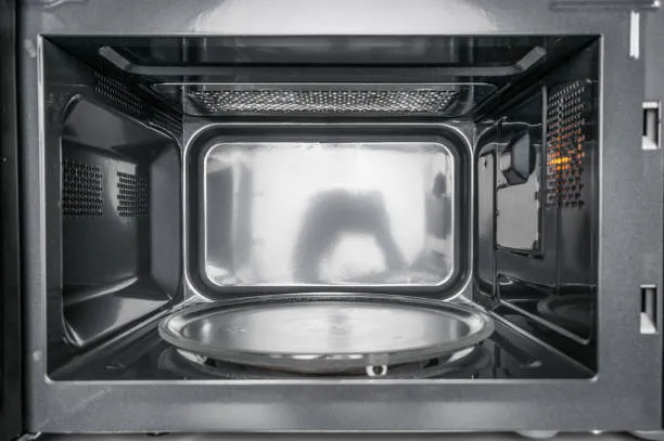 The internal components of a microwave, with a focus on where the capacitor is located.