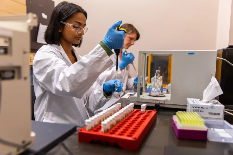 A research lab with engineers working on PCB design and testing.