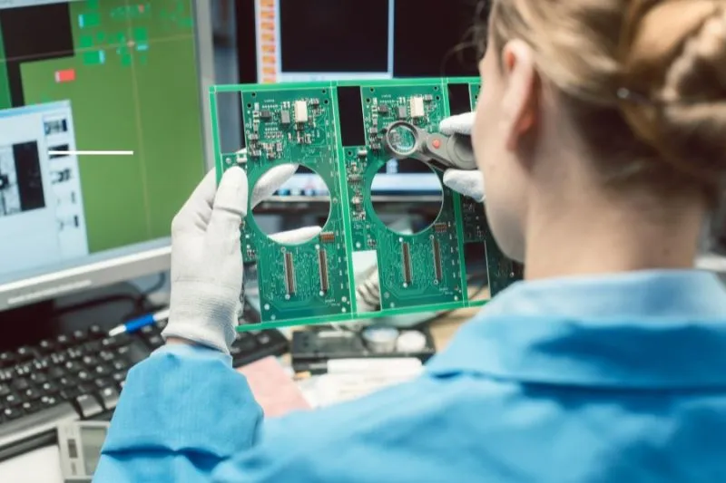 A close up shot of a PCB board being examined under a microscope or inspection machine.