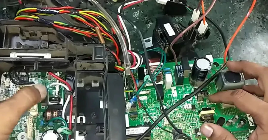 A new AC PCB being installed into the air conditioner.
