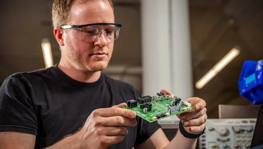 A PCB design engineer working on a computer, reviewing design files.