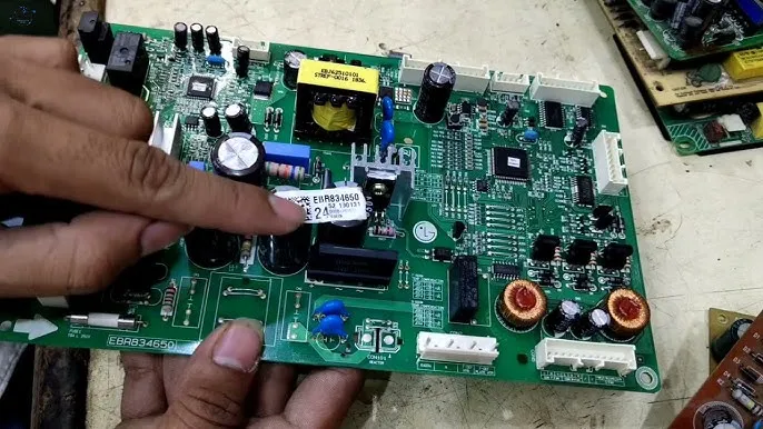 A person replacing a PCB board in a refrigerator.