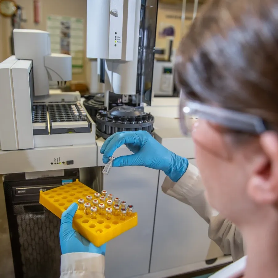 An engineer testing a PCB transformer with measurement equipment in a lab.