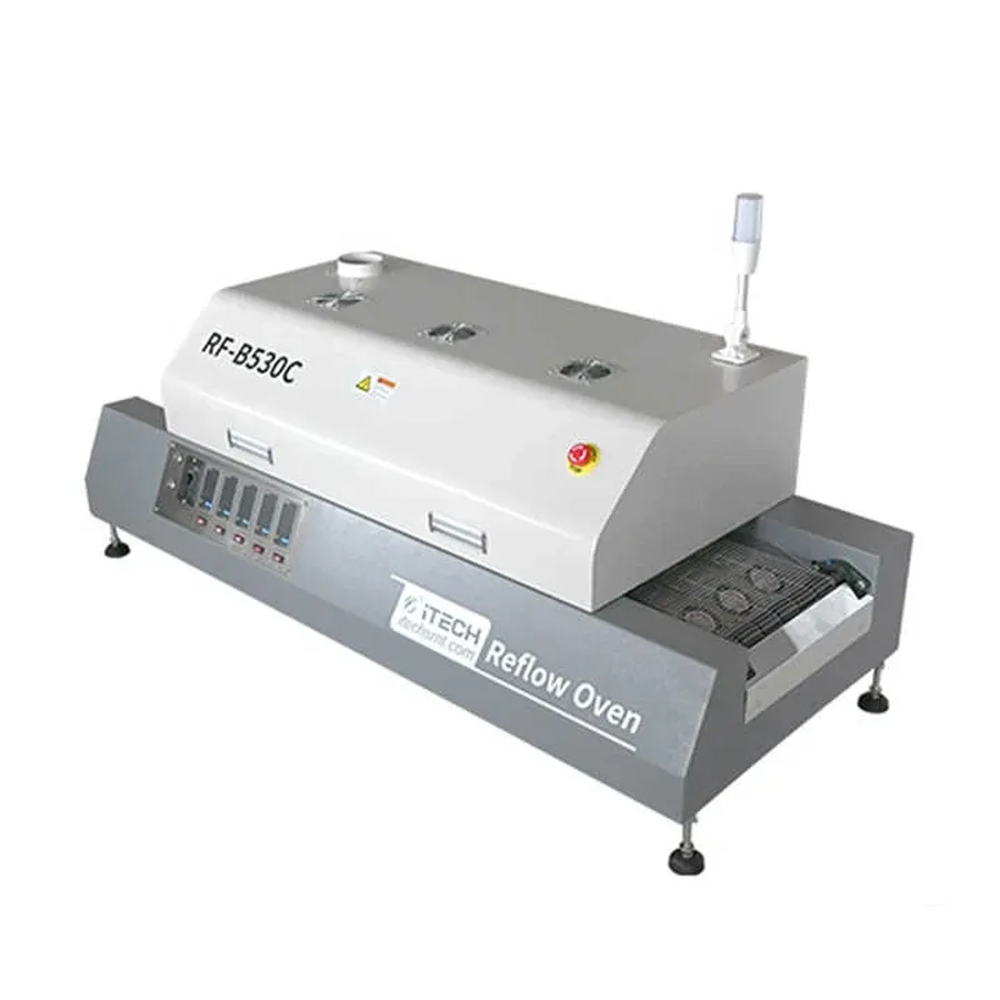 A conveyor belt carrying PCBs through a reflow oven.