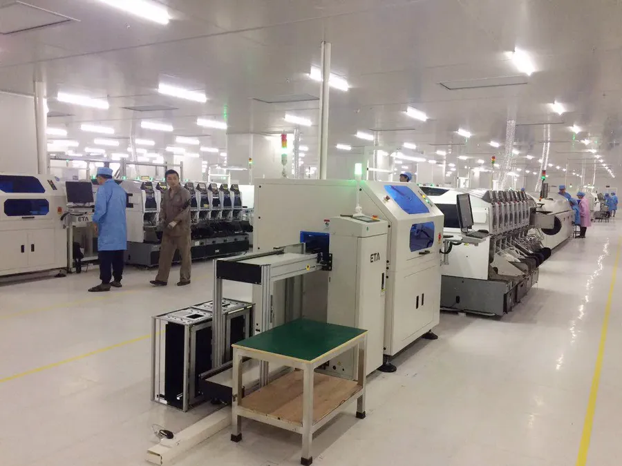 A PCB assembly line with pick and place machines and reflow oven.