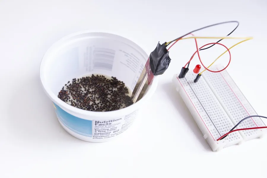 A simple circuit built on a breadboard using a battery, wires, a resistor and an LED.