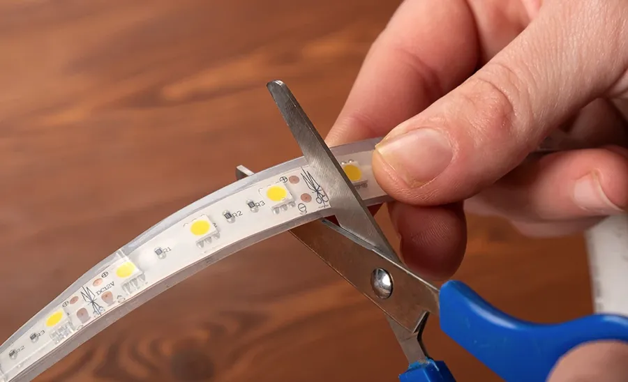 A close up of LED tape light being installed.