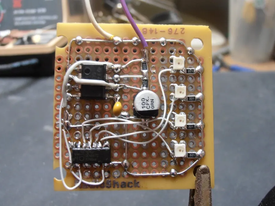 A close-up of soldering connections on a perfboard.