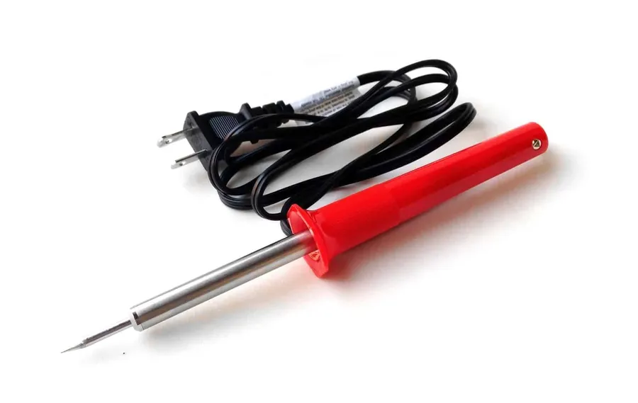 Various soldering tools and components on a workbench.