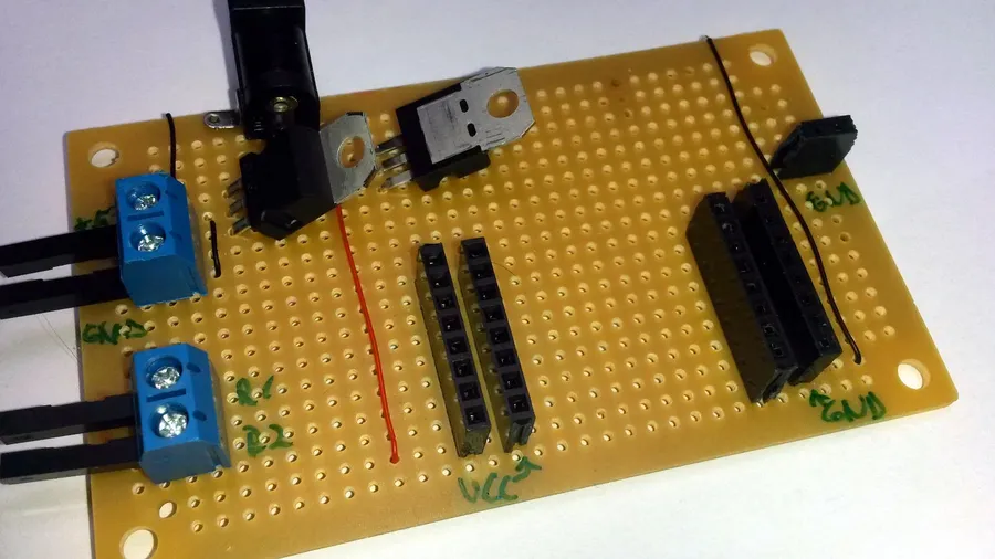 A hand soldering components onto stripboard.