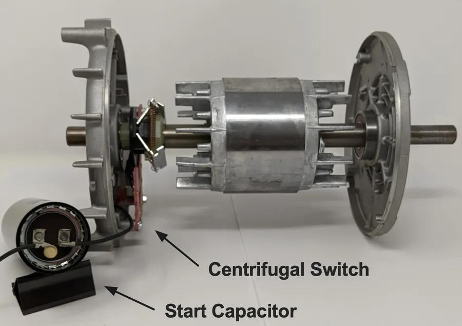 Hands replacing a motor run capacitor in an electrical box.