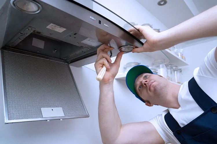 Technician repairing a kitchen chimney.
