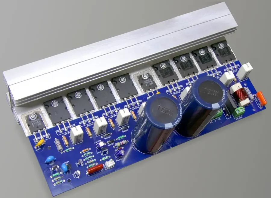 A hand assembling a DIY amplifier circuit board.