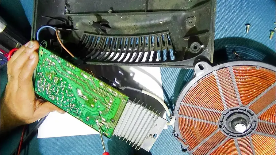 A close-up of a repaired section on an induction cooker PCB board.