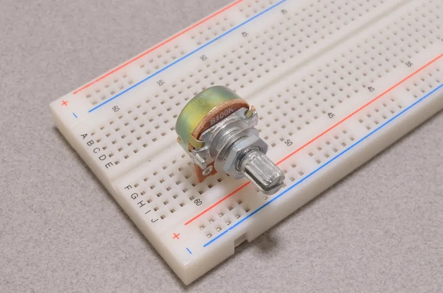 A 100k ohm resistor on a breadboard in a circuit.