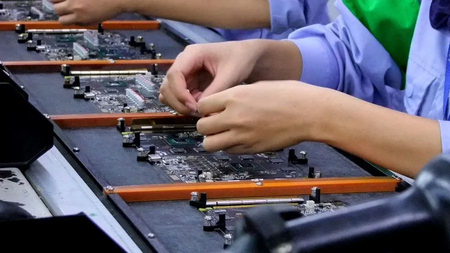 A motherboard being assembled in a factory setting.