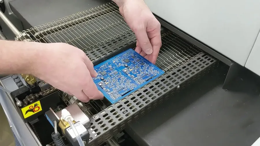 A person assembling electronic components onto a circuit board.