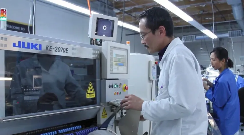 A technician working on a PCB assembly line.