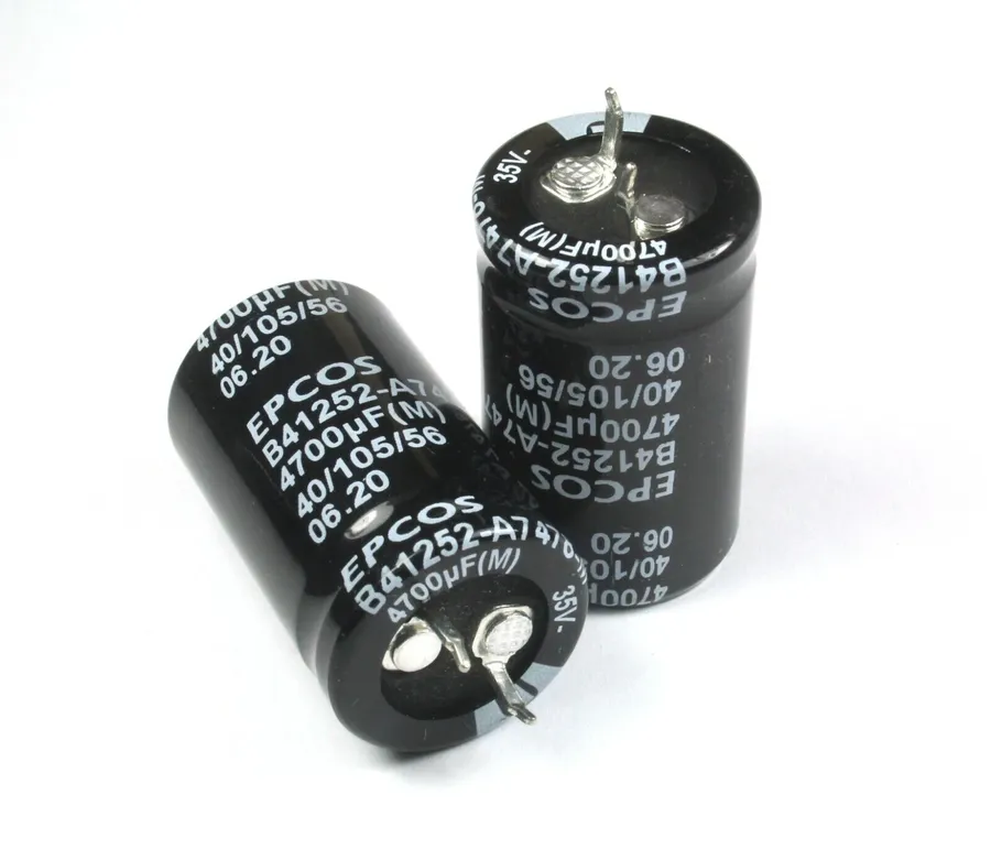 A close-up of a TDK aluminum electrolytic capacitor with snap-in terminals.