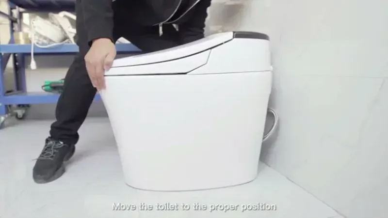 A technician installing a smart toilet with visible electronic components